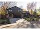 Exterior front view of a home with stone accents, a black garage door, and a well-kept lawn at 4269 Carter Trl, Boulder, CO 80301