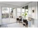 Bright sunroom with white shiplap walls, two chairs, a rug, and a sliding glass door to the deck at 4269 Carter Trl, Boulder, CO 80301