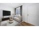 Cozy living room with a comfortable sofa, TV, and window with natural light at 3908 N Riviera Ct, Aurora, CO 80019