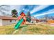 The backyard features a wooden playset, a small shed, a grass lawn and a beautiful blue partly cloudy sky at 3387 S Pitkin Way, Aurora, CO 80013