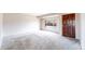 Bright, spacious living room featuring neutral walls, new carpet and a stylish wood front door at 3387 S Pitkin Way, Aurora, CO 80013