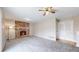 Spacious living room featuring a brick fireplace, ceiling fan, and neutral carpet at 3387 S Pitkin Way, Aurora, CO 80013