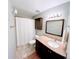 A full bathroom with a single sink vanity, mirror, neutral tile floors, and a shower with a white curtain at 3209 Redstone Rd # 12B, Boulder, CO 80305