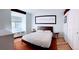 Bright bedroom with a dark wood bed frame, bedside tables, white walls, and warm wood flooring at 3209 Redstone Rd # 12B, Boulder, CO 80305