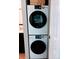 Compact laundry area features a stacked washer and dryer with digital displays and a white door at 3209 Redstone Rd # 12B, Boulder, CO 80305