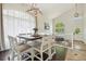Bright dining area featuring a rustic chandelier, a large window with sheer curtains, and stylish decor creating an inviting space at 4520 Maroon Cir, Broomfield, CO 80023