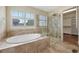 Bright bathroom featuring soaking tub, frameless shower and tiled surround at 5531 Fox Meadow Ave, Highlands Ranch, CO 80130
