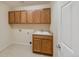 Laundry room with upper and lower wood cabinets and tile floors at 5531 Fox Meadow Ave, Highlands Ranch, CO 80130