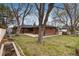 Brick home boasts a spacious backyard with mature trees, a patio, and a garden bed at 5743 Field St, Arvada, CO 80002