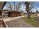 A spacious backyard featuring a patio with wooden chairs, gravel, and a large tree offering shade at 5743 Field St, Arvada, CO 80002