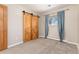 Comfortable bedroom featuring plush carpeting, ample natural light, and a unique barn door closet enhancing its appeal at 5743 Field St, Arvada, CO 80002
