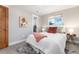 The bright bedroom has plush carpet, a neutral color palette, and an ensuite bathroom at 5743 Field St, Arvada, CO 80002