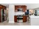 Modern kitchen with stainless steel appliances and wood cabinets, seamlessly connecting to the living space for open-concept living at 5743 Field St, Arvada, CO 80002