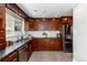 Modern kitchen with wood cabinets, granite countertops, stainless steel appliances, and a view from the window over the sink at 5743 Field St, Arvada, CO 80002