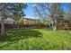 Enjoy the spacious backyard featuring a lush lawn, wooden fence, and playset at 7773 Brentwood Ct, Arvada, CO 80005