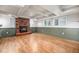 Finished basement with a brick fireplace, wood floors, and ample space with natural light at 7773 Brentwood Ct, Arvada, CO 80005