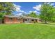 Charming home featuring a well-manicured lawn, mature trees, and welcoming facade creating a warm curb appeal at 423 Nile St, Aurora, CO 80010