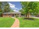Charming ranch-style home with brick accents, lush lawn, and a brick walkway leading to the front door at 423 Nile St, Aurora, CO 80010