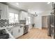 Bright kitchen featuring white cabinets, stainless steel appliances, and unique tile backsplash at 423 Nile St, Aurora, CO 80010