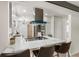 Well-equipped kitchen featuring an island cooktop, modern vent hood, and adjacent breakfast bar seating area at 423 Nile St, Aurora, CO 80010