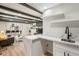 Open-concept living space with wet bar, fireplace, exposed beams, and modern decor at 423 Nile St, Aurora, CO 80010