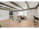 Cozy living room with beamed ceilings, open to the modern kitchen, with lots of natural light from a large window at 423 Nile St, Aurora, CO 80010
