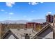 Residential view features buildings and mountains against a blue sky with bright white clouds from a rooftop at 257 Jackson St, Denver, CO 80206