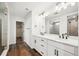 Bathroom highlighting double sink vanity, quartz countertops, wood look floors and a walk in closet at 5614 Riverbend Ave, Firestone, CO 80504