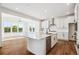 Bright kitchen featuring white cabinets, a center island with a sink, and stainless steel appliances at 5614 Riverbend Ave, Firestone, CO 80504