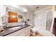 Clean bathroom with a bathtub, vanity, and a large mirror at 775 S Alton Way # 3D, Denver, CO 80247