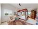 Bedroom with a four poster bed, shuttered windows, and an arm chair by the window at 775 S Alton Way # 3D, Denver, CO 80247