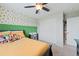 Bedroom with plush carpet, a window, a ceiling fan, and a storage unit for organizing toys at 11870 Cattle Ln, Parker, CO 80134