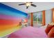 Bright bedroom featuring an accent wall, window, plush carpet and a ceiling fan at 11870 Cattle Ln, Parker, CO 80134