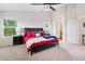 Bright main bedroom featuring plush carpet, ceiling fan, and ensuite bathroom with vanity and tub at 11870 Cattle Ln, Parker, CO 80134