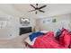 Bright main bedroom boasts plush carpeting, a ceiling fan, and black dresser with a wall mounted TV at 11870 Cattle Ln, Parker, CO 80134