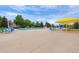 Community pool and lounge area features bright yellow sunshades, chairs and trees against a blue sky at 11870 Cattle Ln, Parker, CO 80134