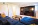 Relaxing basement living space showcasing a blue sectional, large entertainment center, and stylish decor at 9512 W Ontario Dr, Littleton, CO 80128