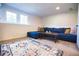 Cozy basement living area featuring a sectional sofa, decorative rug, and plenty of natural light at 9512 W Ontario Dr, Littleton, CO 80128