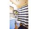 Well-lit bathroom features a vanity, a shower with a blue and white striped curtain, and modern fixtures at 9512 W Ontario Dr, Littleton, CO 80128