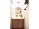 Clean bathroom featuring a vanity with ample storage and a round mirror at 9512 W Ontario Dr, Littleton, CO 80128