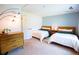 A well-lit bedroom featuring two twin beds, neutral walls and a modern light fixture at 9512 W Ontario Dr, Littleton, CO 80128
