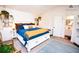 Relaxing bedroom features a white bed with storage drawers, charming decor, and a view of the en suite bathroom at 9512 W Ontario Dr, Littleton, CO 80128