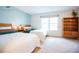 Bright bedroom with two twin beds, large window, and stylish wooden bookshelf providing ample storage at 9512 W Ontario Dr, Littleton, CO 80128
