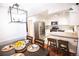 Bright dining area with stainless steel appliances, white cabinets and a modern light fixture at 9512 W Ontario Dr, Littleton, CO 80128