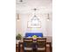 A dining room with a modern light fixture, and a blue bench with a painting hanging on the wall at 9512 W Ontario Dr, Littleton, CO 80128