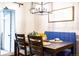 A dining room with a modern light fixture, and a blue bench with a view to the patio outside at 9512 W Ontario Dr, Littleton, CO 80128