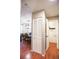 Hallway view with wood flooring and a view of the dining room and a half bathroom with white closet doors at 9512 W Ontario Dr, Littleton, CO 80128