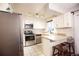 Bright kitchen featuring stainless steel appliances, tile flooring, light counter tops and white cabinets at 9512 W Ontario Dr, Littleton, CO 80128