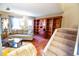 Bright and airy living room featuring hardwood floors, a staircase, and a large bookcase at 9512 W Ontario Dr, Littleton, CO 80128