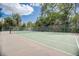 Outdoor tennis court with green surface surrounded by trees and a chain-link fence on a sunny day at 2900 Shadow Creek Dr # 201, Boulder, CO 80303